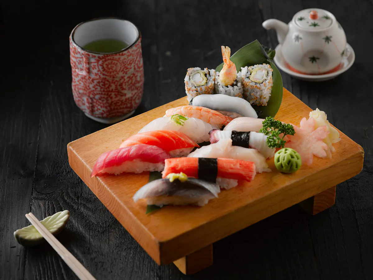 Assorted nigiri sushi platter with green tea and teapot at Love Sushi, a Japanese Restaurant in Thornton