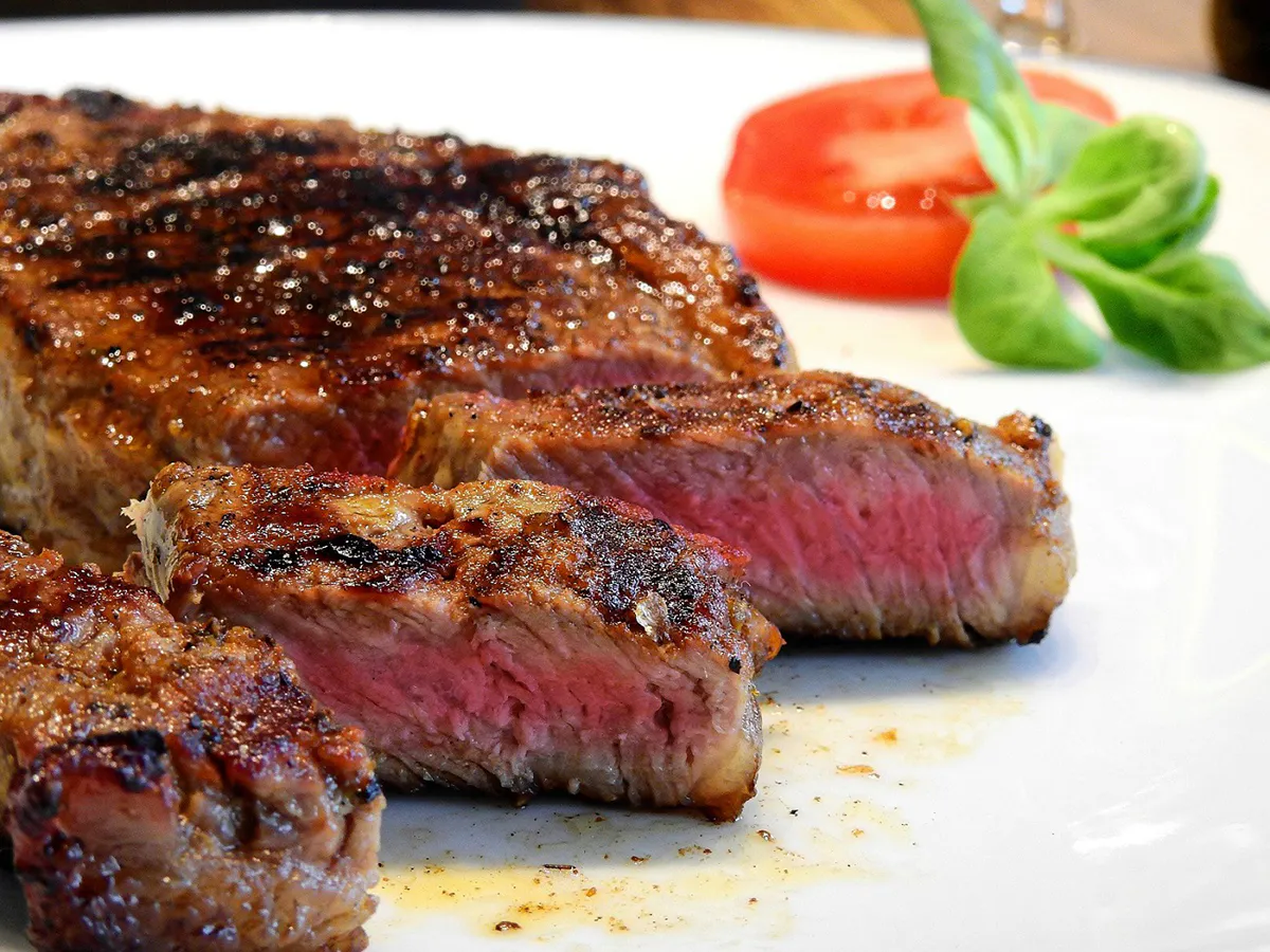 Grilled medium-rare steak garnished with tomato and basil at Love Sushi, a Japanese Restaurant in Thornton