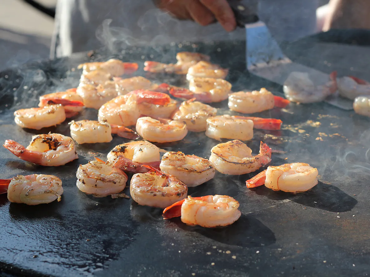 Grilled seasoned shrimp sizzling on a hot flat top grill at Love Sushi, a Japanese Restaurant in Thornton